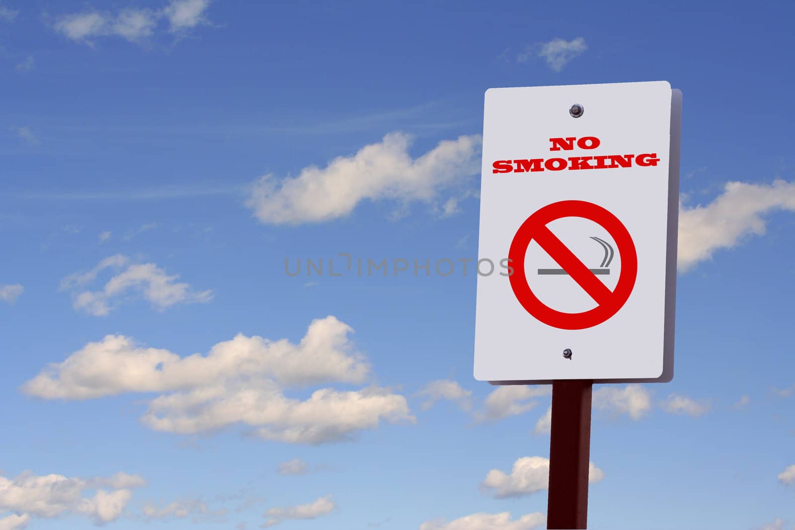 No smoking sign on a post against a blue sky with puffy white clouds