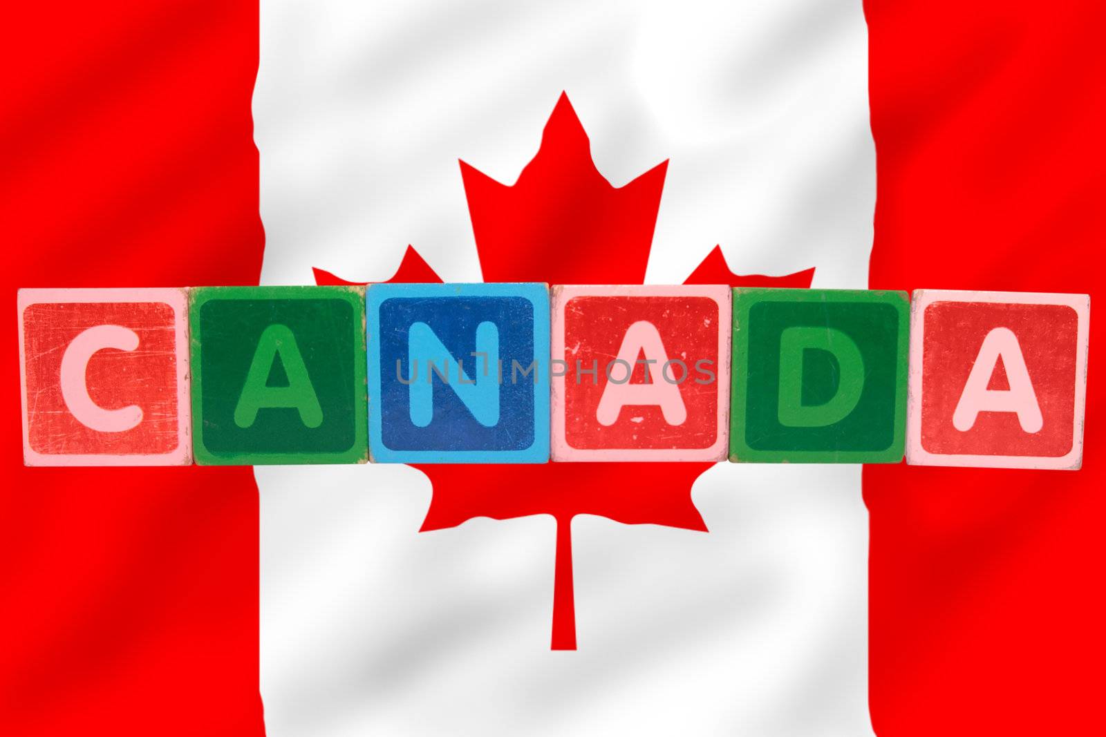 toy letters that spell canada against a flag background with clipping path
