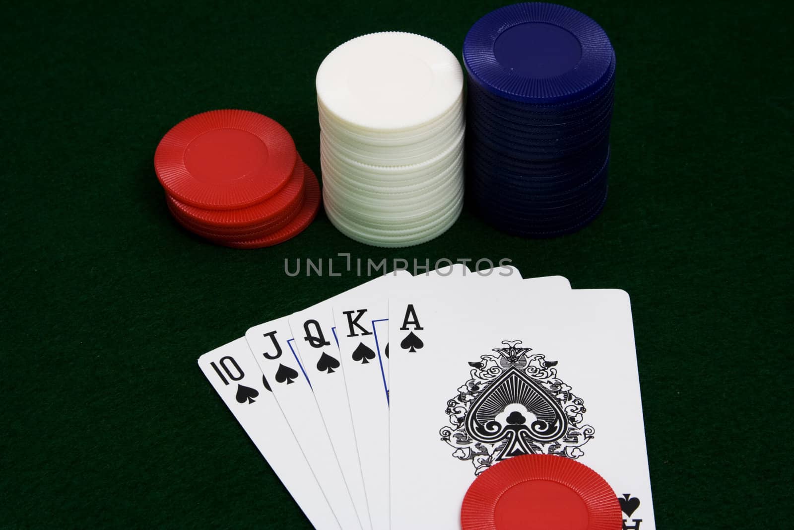 straight flush ace high over green felt with three stacks of chips shot close up