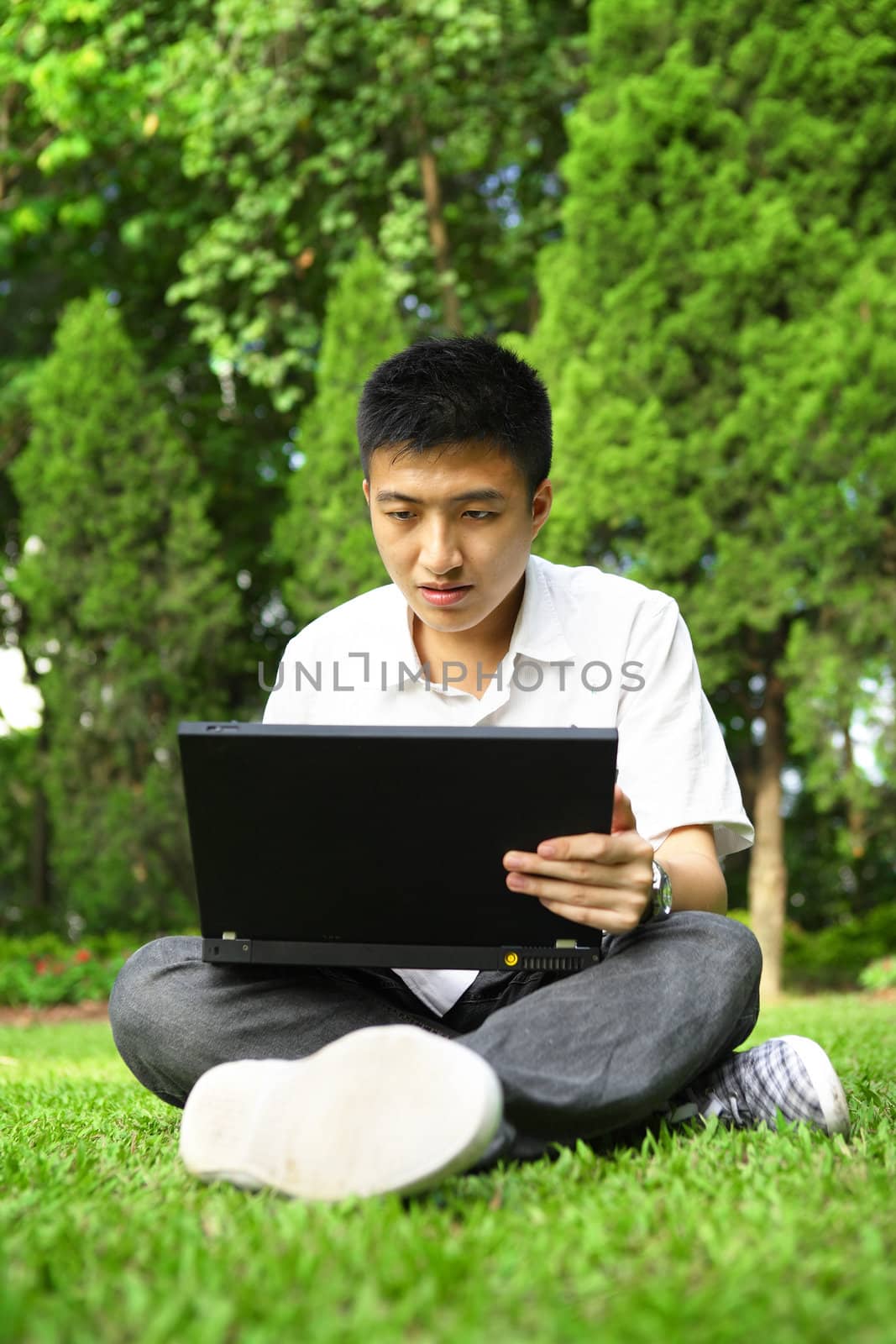 asian man using computer outdoor by leungchopan