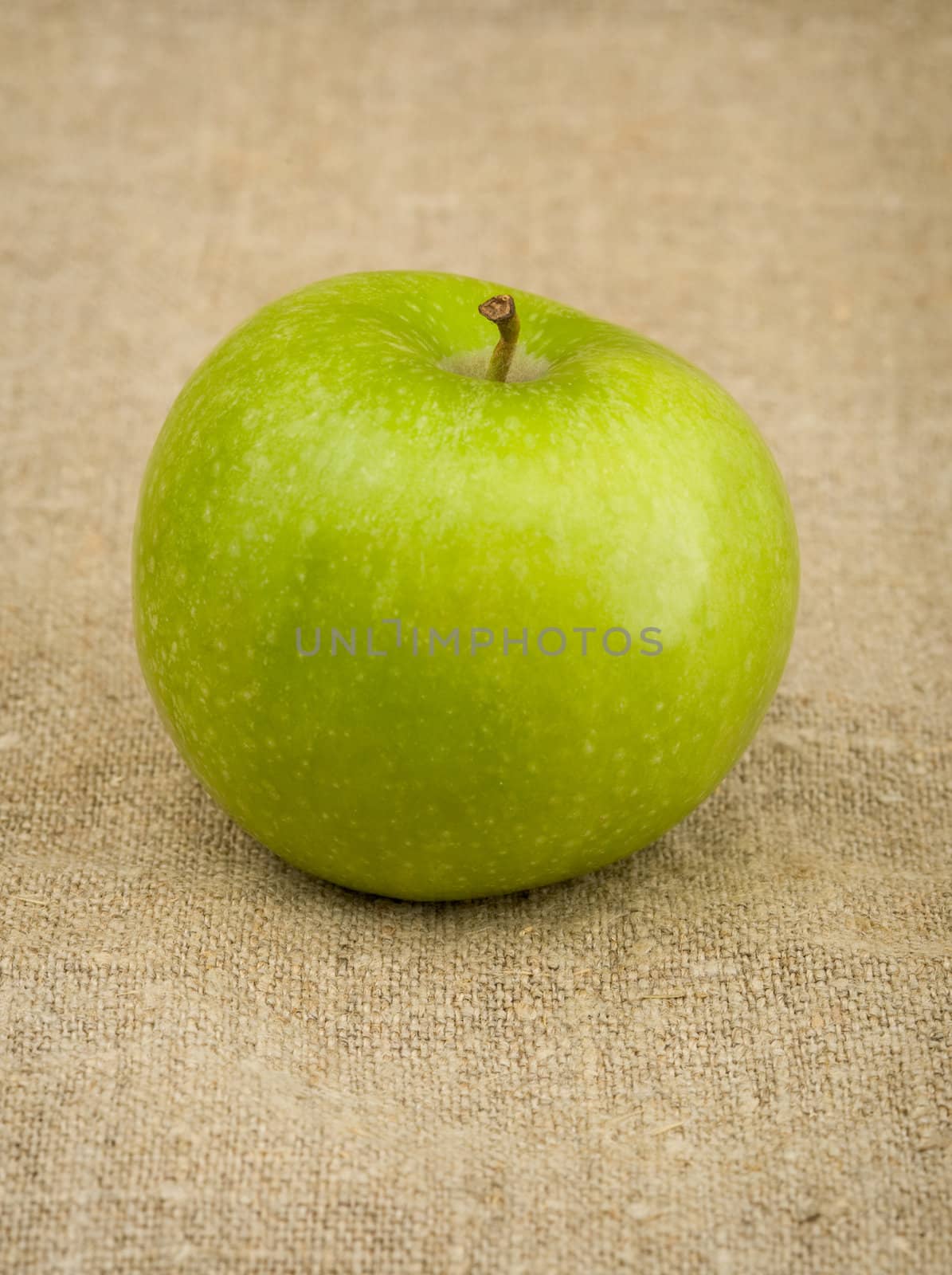 Green apple on the brown sacking background