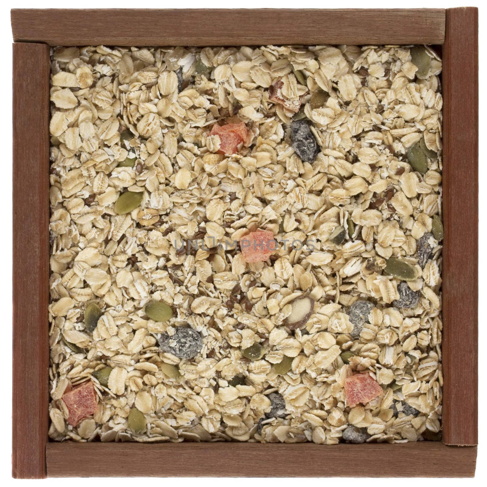 muesli cereal in a wooden box or frame - rolled oats with papaya fruit, pepita and raisins