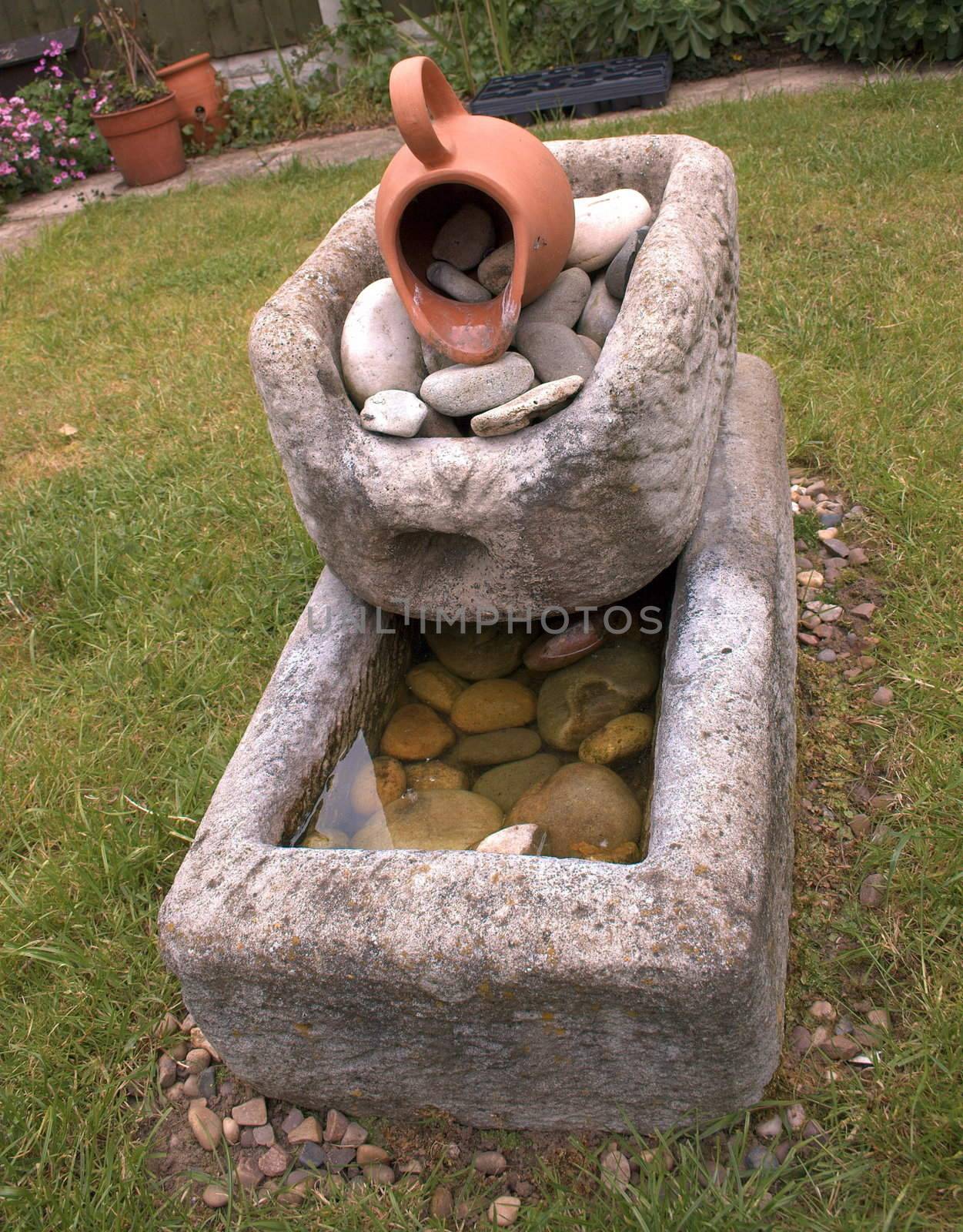 water fountain made of stone standing as a garden feature on the lawn