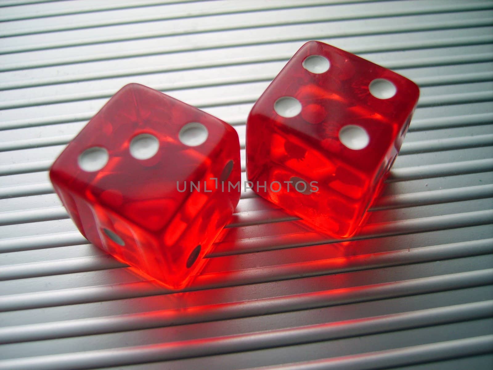 an image with two red casino dice showing a three and a four