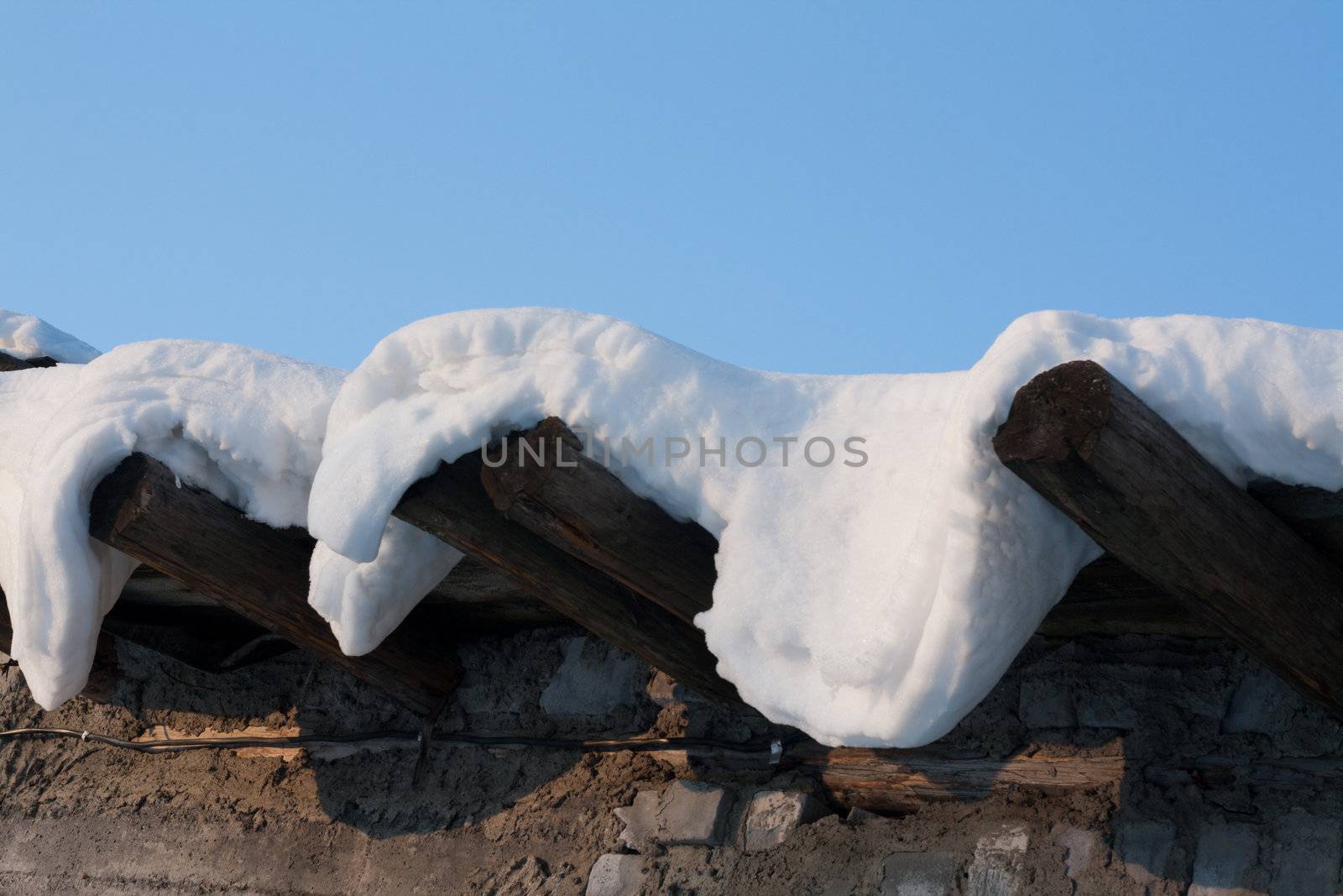 Wooden roof, drooping snow, winter, sunny, blue sky