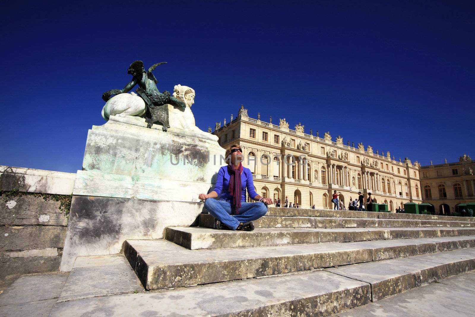 The woman meditates on a background of Chapel of Versailles Palace. France