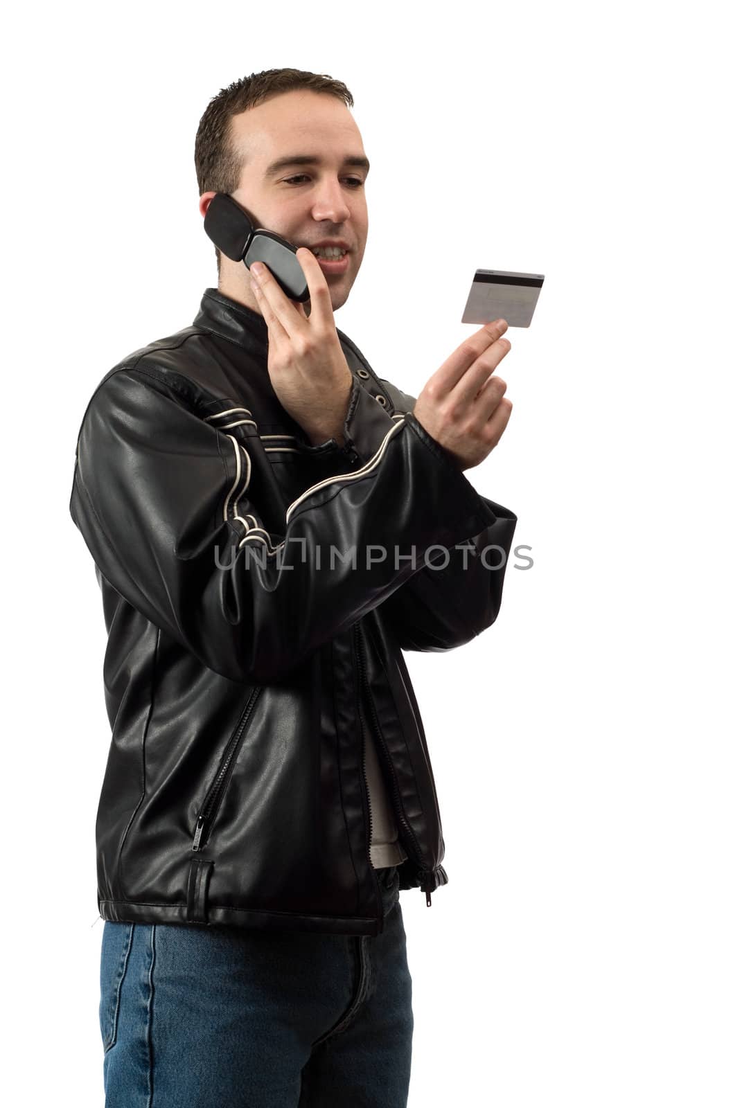 A young man doing some telephone banking and giving the bank his debit card number, isolated against a white background