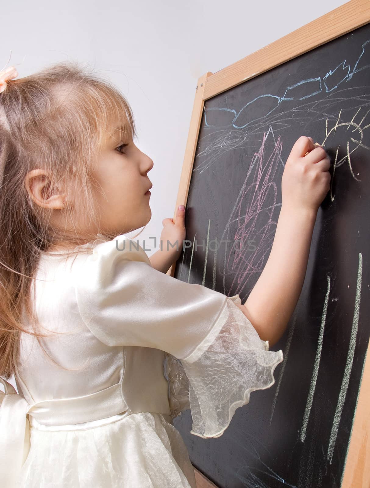 Girl of five years, drawing on the blackboard
