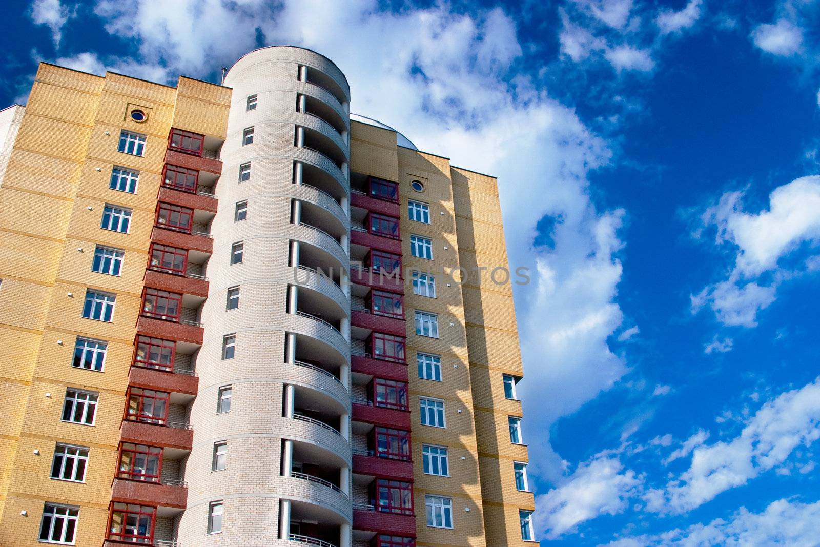 Modern tall residential building on a background of blue sk