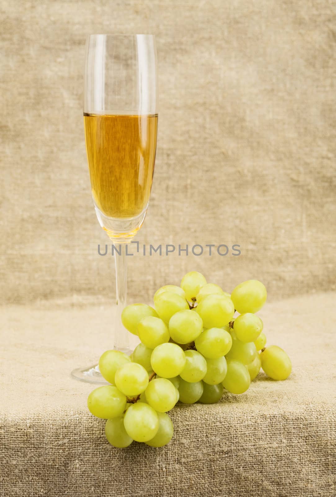 Still-life with a glass of wine and grapes on sacking background