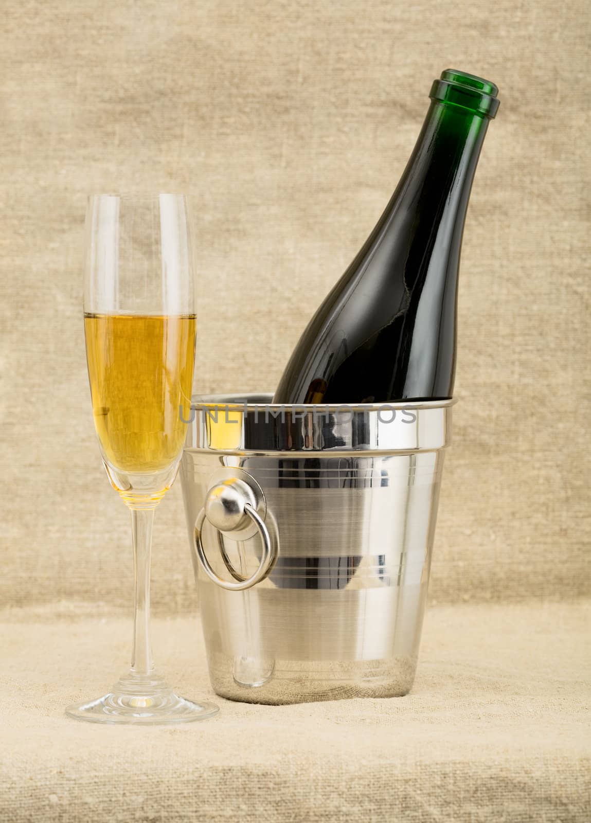 Still-life with a glass of wine and a bottle on sacking background