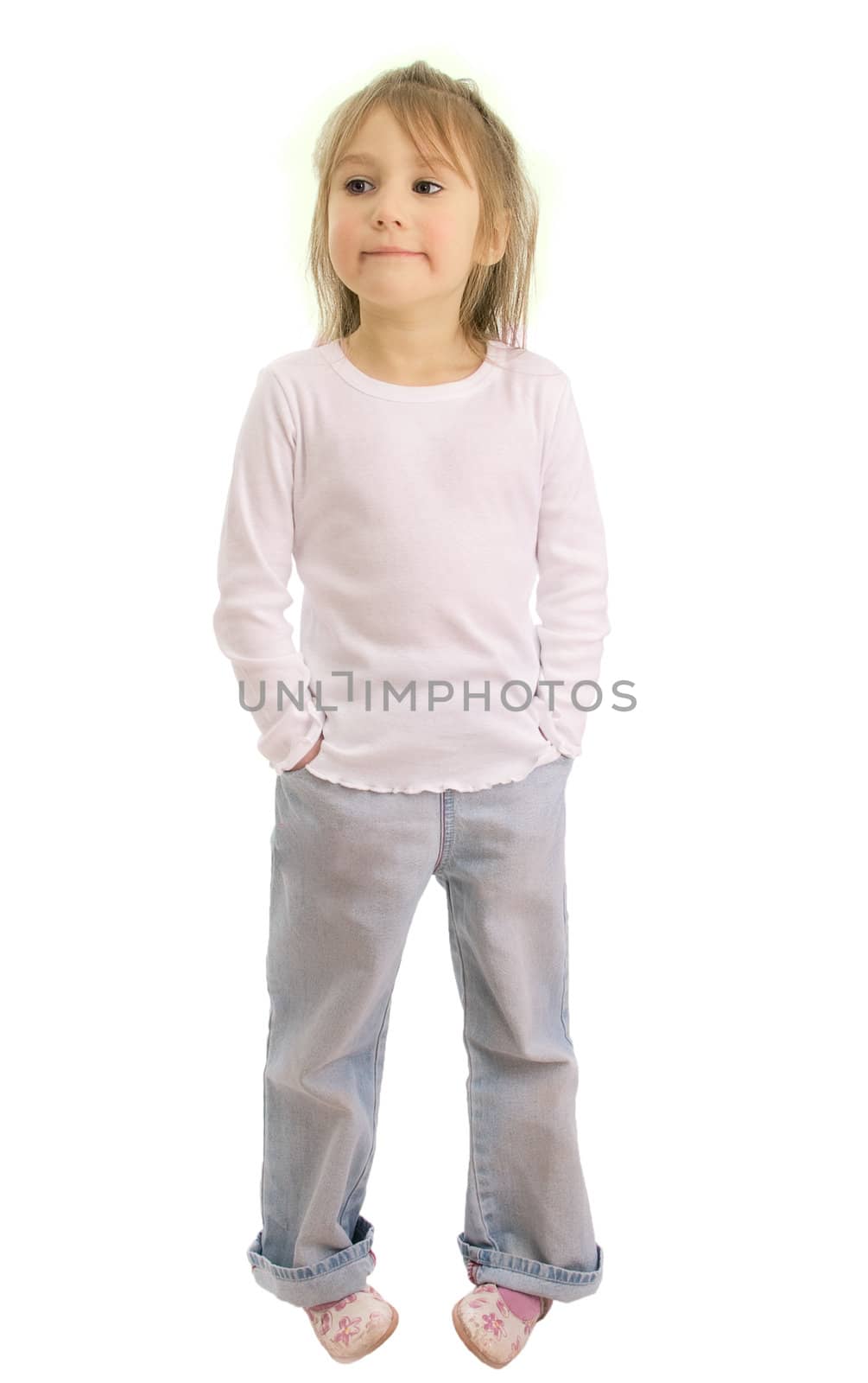 Girl of five years in a white shirt and blue jeans isolated on a white background. She smiles, the look is directed towards
