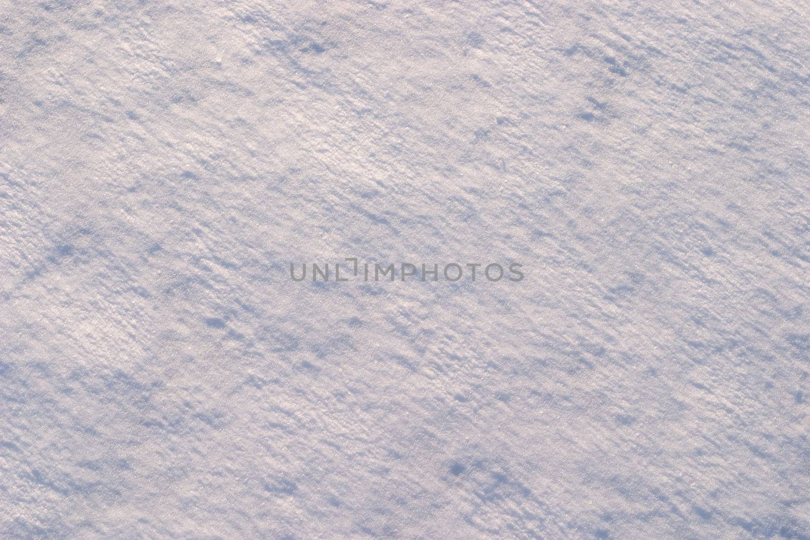 Texture of the snow. Thin snow crust on the surface of the frozen lake. Natural sunlight emphasizes texture. Pattern # 1