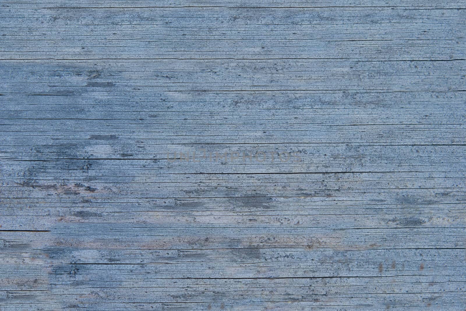 Old wooden blue painted surface. The paint is faded and cracked, you can see small cracks. Uniform illumination and a wide tonal range, sharpness is not increased. For any designer's use, opportunities for marine, coastal theme.