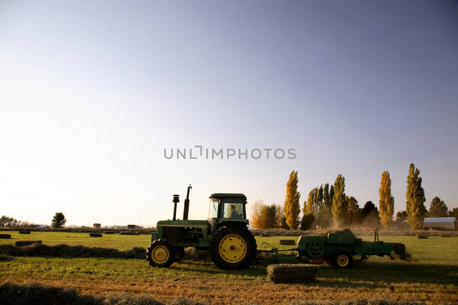 A tractor baling hay in Northwest America in fall
