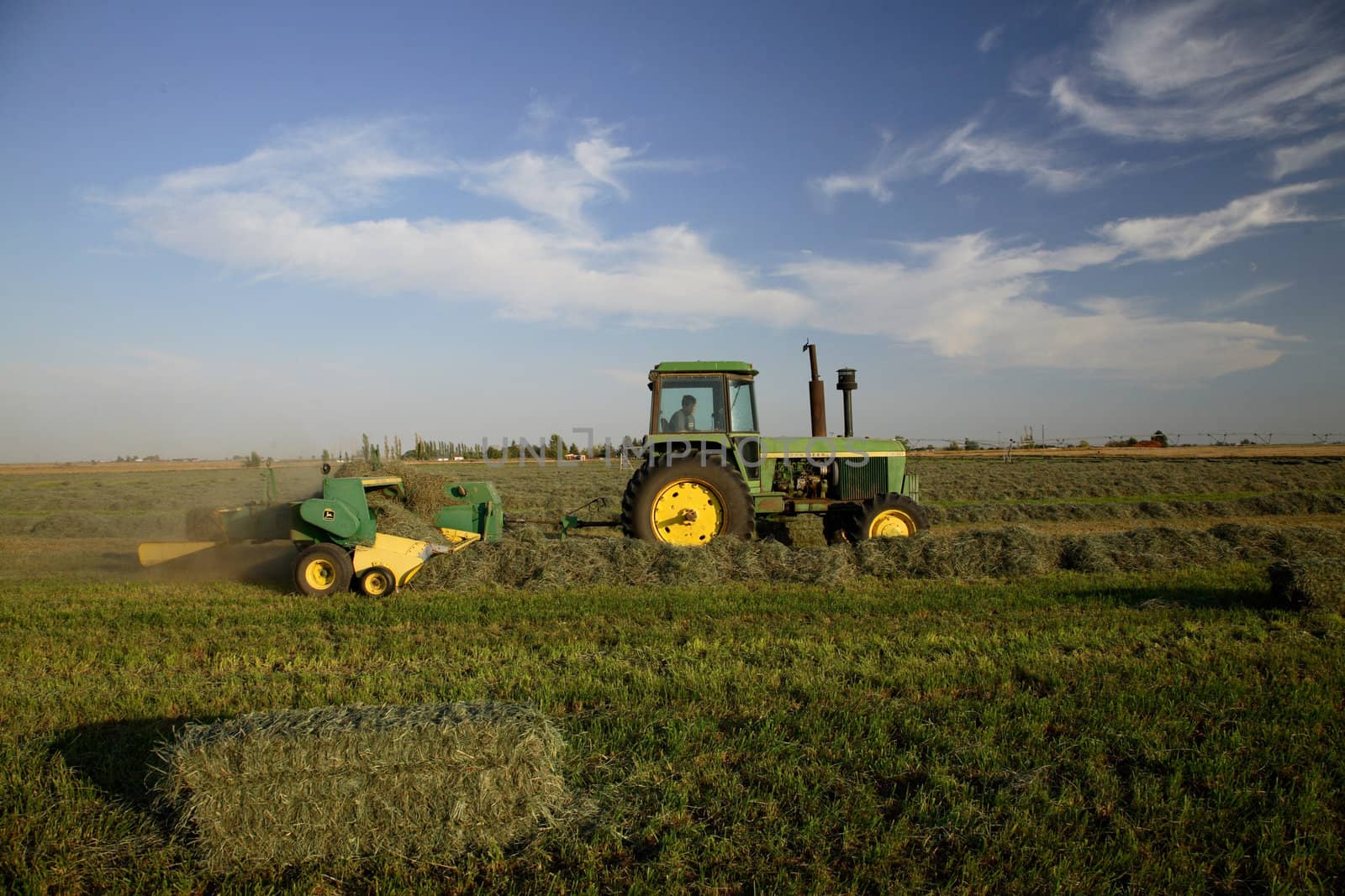 A tractor baling hay in Northwest America in fall
