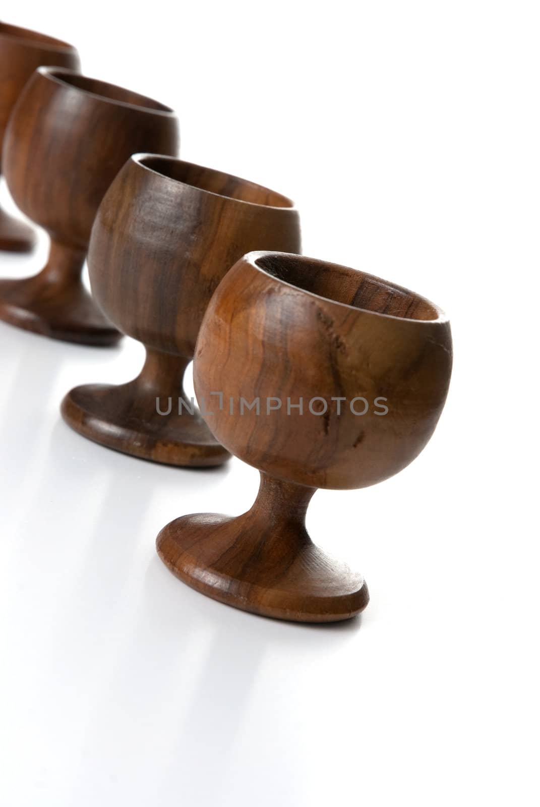 Wooden cups aligned isolated on white background.