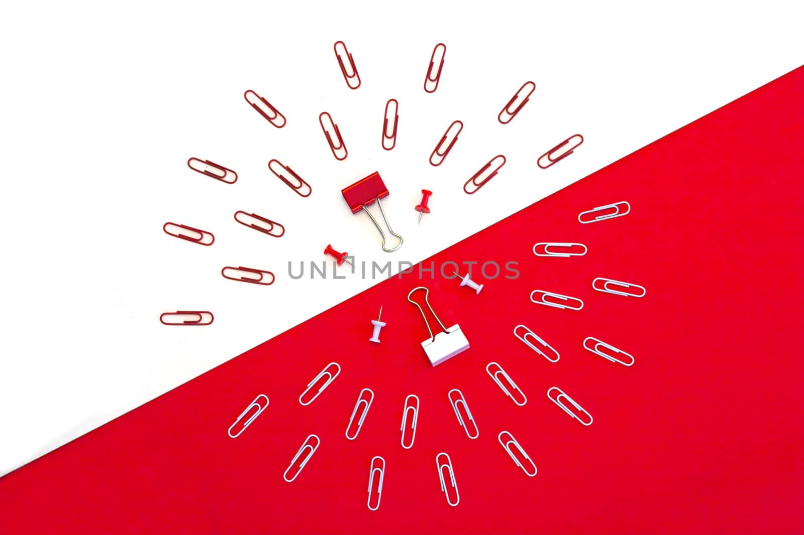 Paper clips located at opposite patters on white and red backgrounds