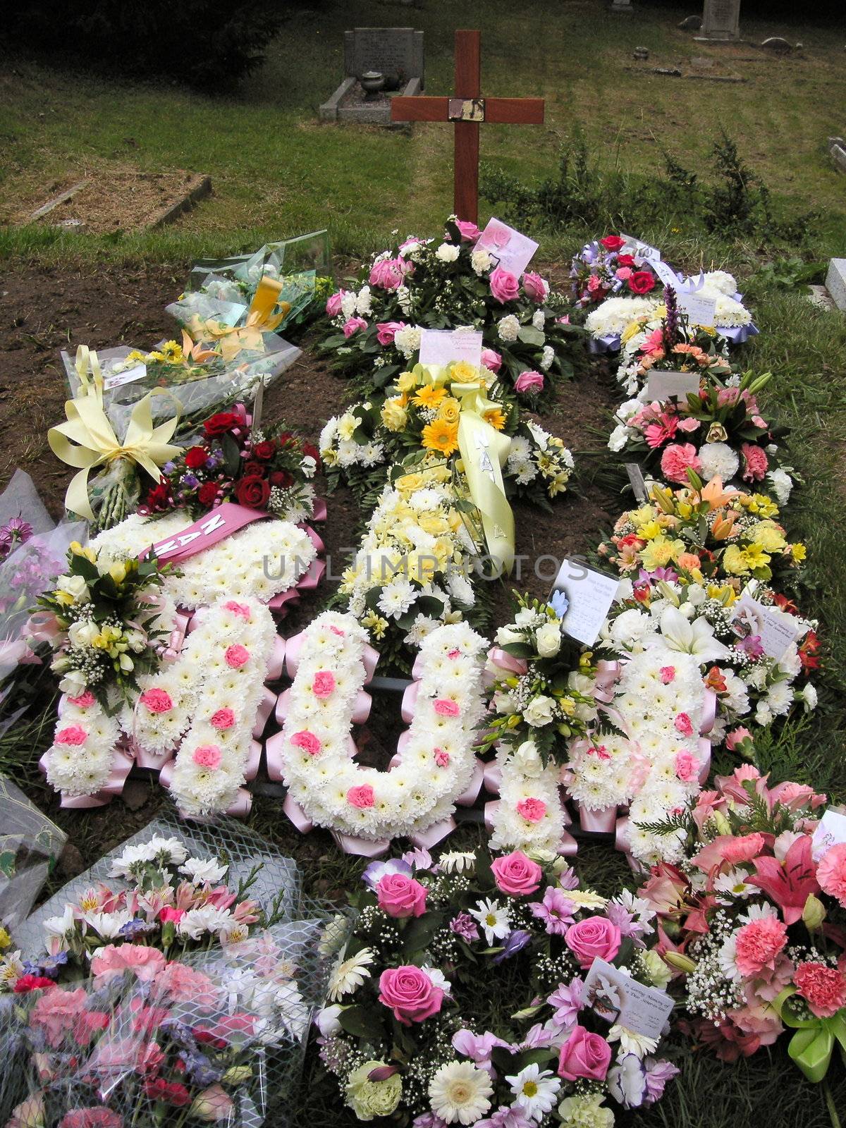 different funeral flowers and wreaths on mums grave