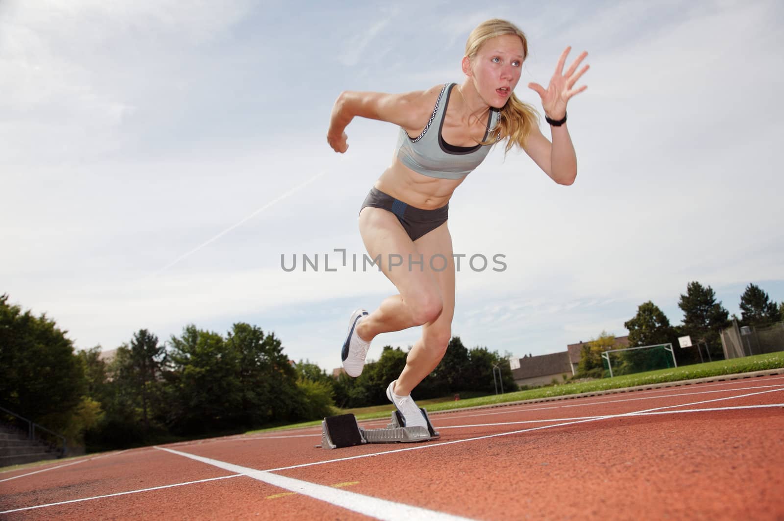 A female athlete runs off the starting block
