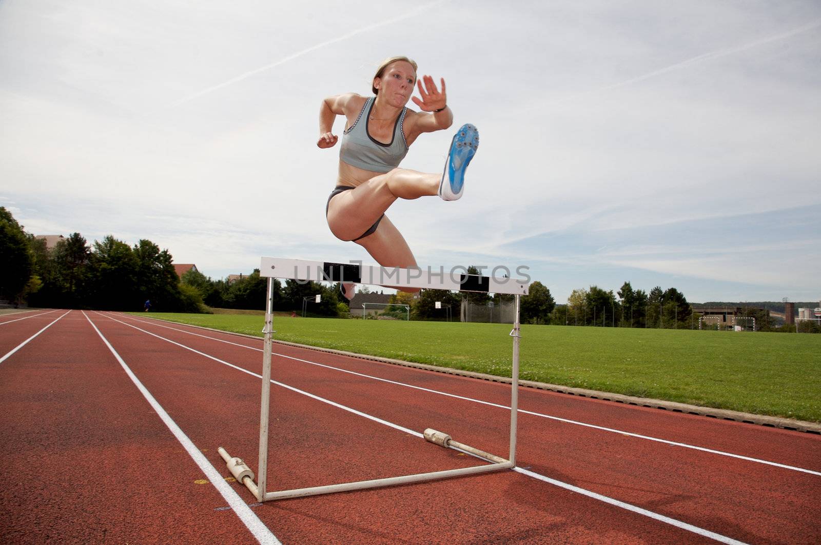 A young athlete jumping over a hurdle
