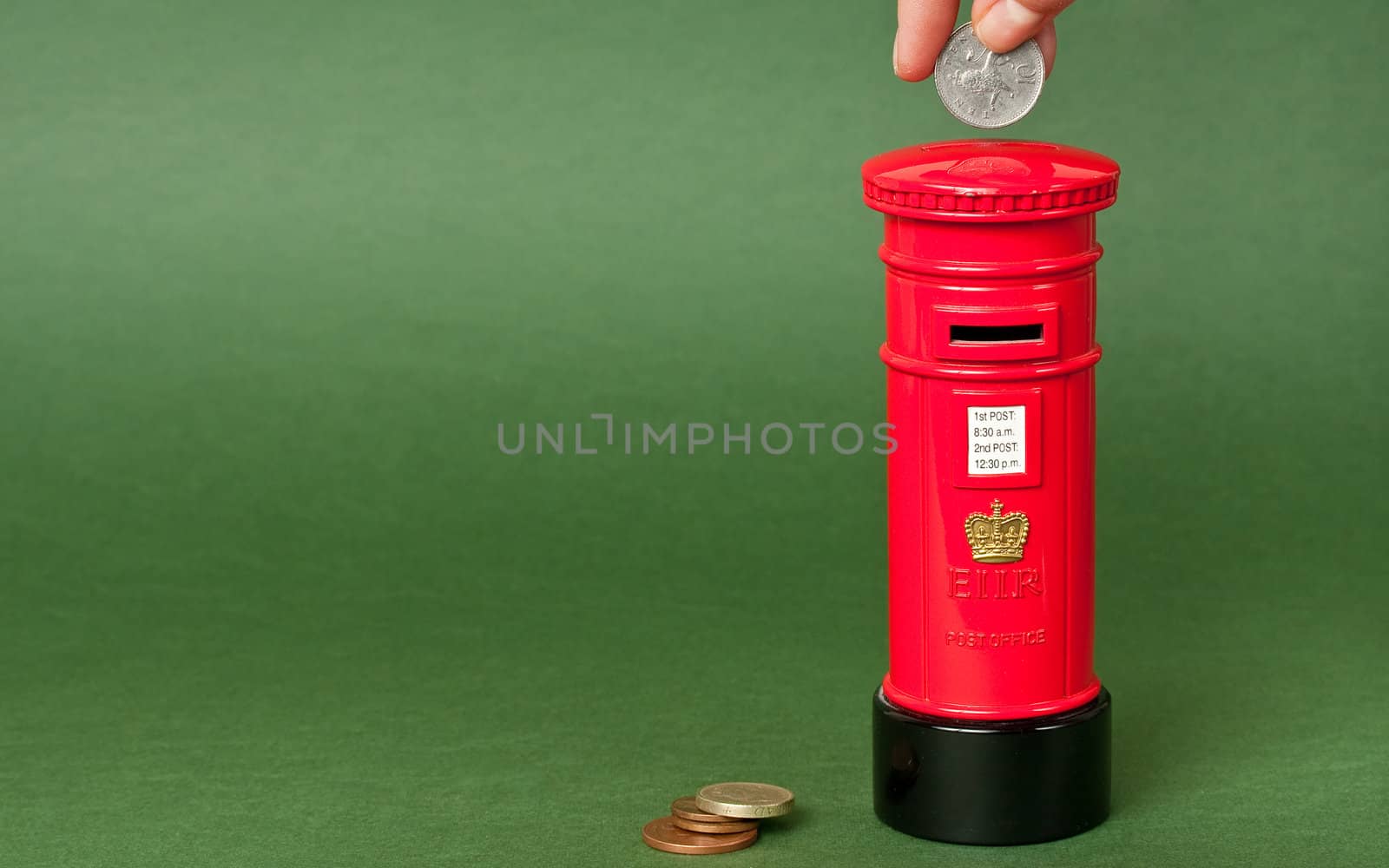 Saving coins in a british mailpost styled piggybank with space for your text