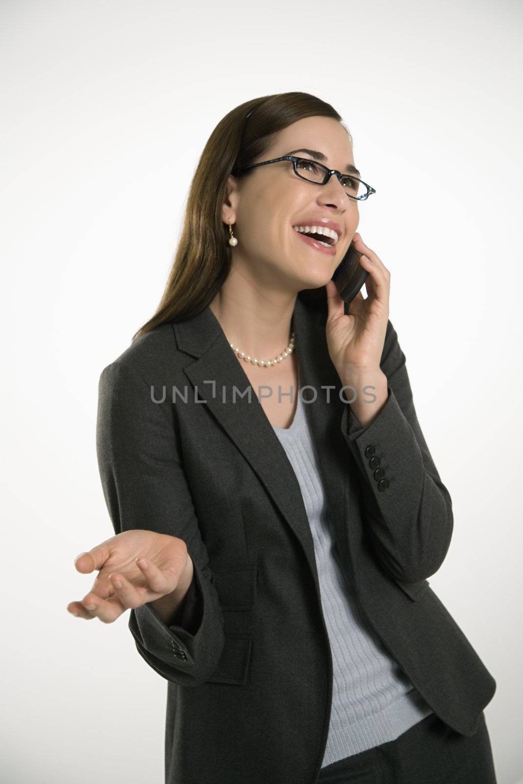Caucasian mid adult professional business woman talking on cell phone with hand out and smiling.