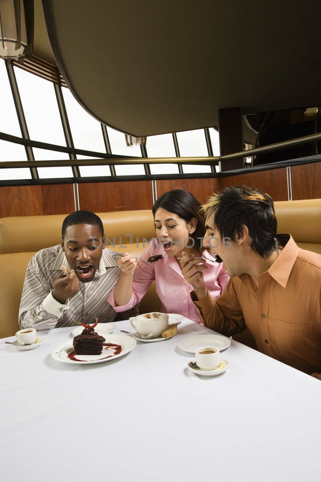 Small group of mid adult friends eating dessert at a restaurant.
