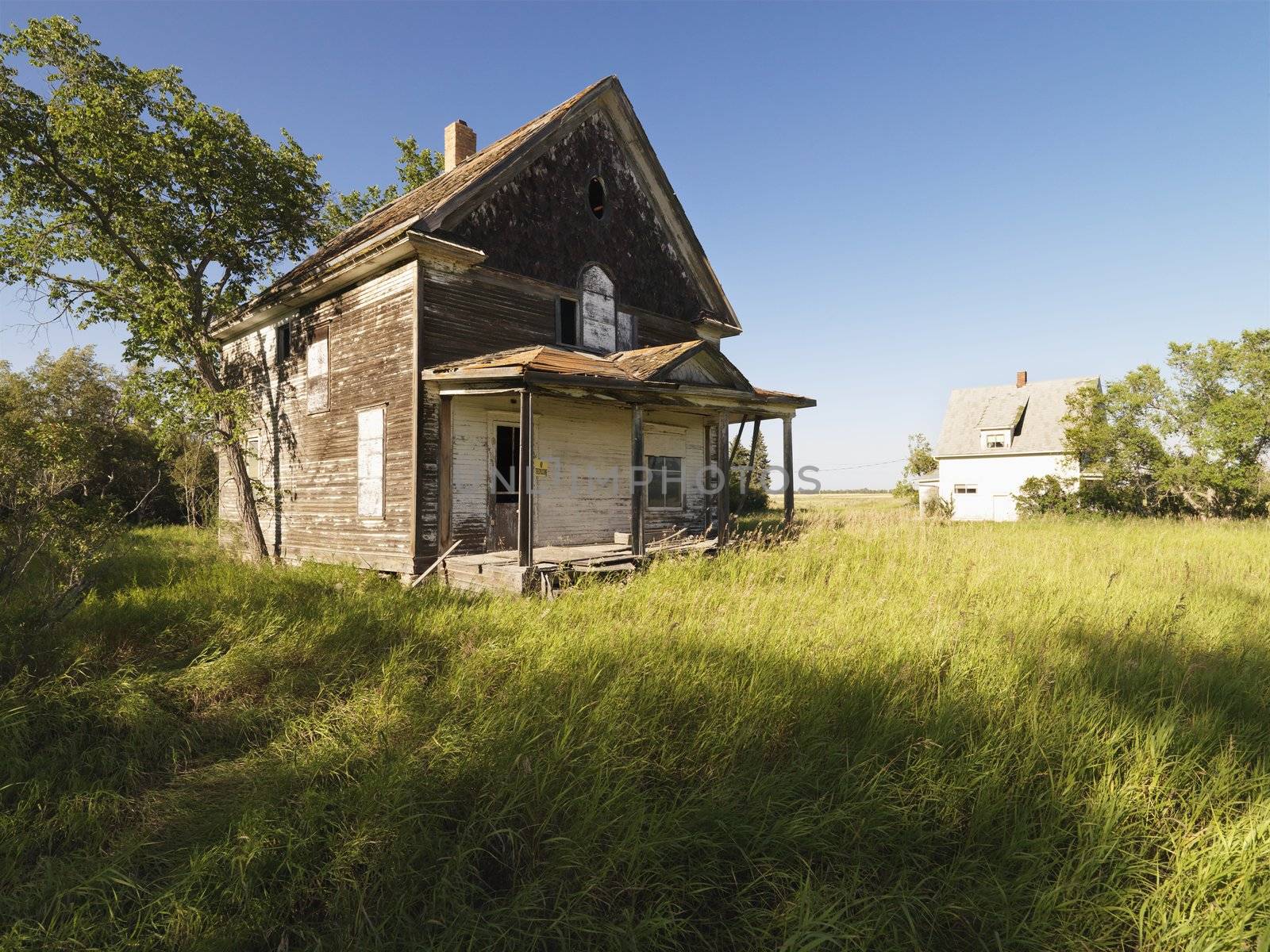 Abandoned farm house in rural field.