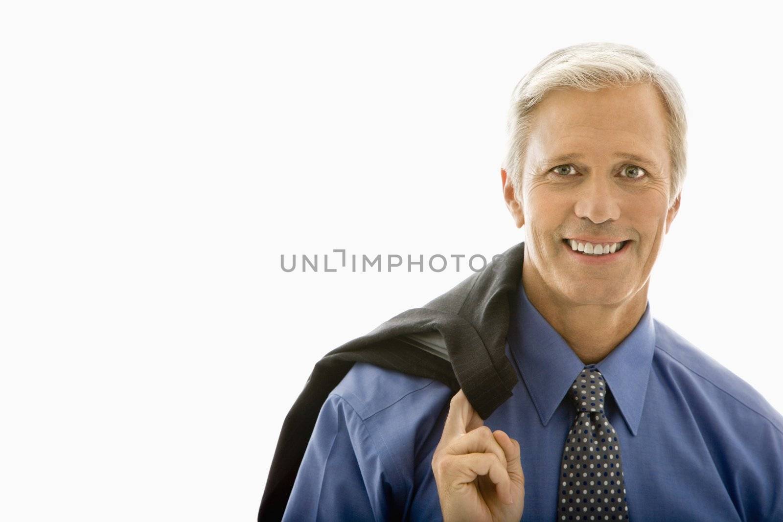 Middle aged Caucasian man in business suit smiling at viewer with jacket draped over shoulder.