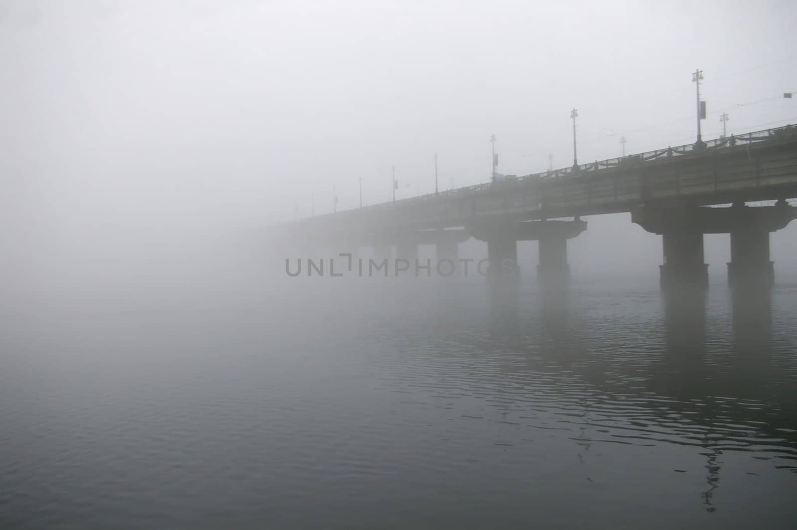 View of entire length of bridge with fog obscuring top of bridge.