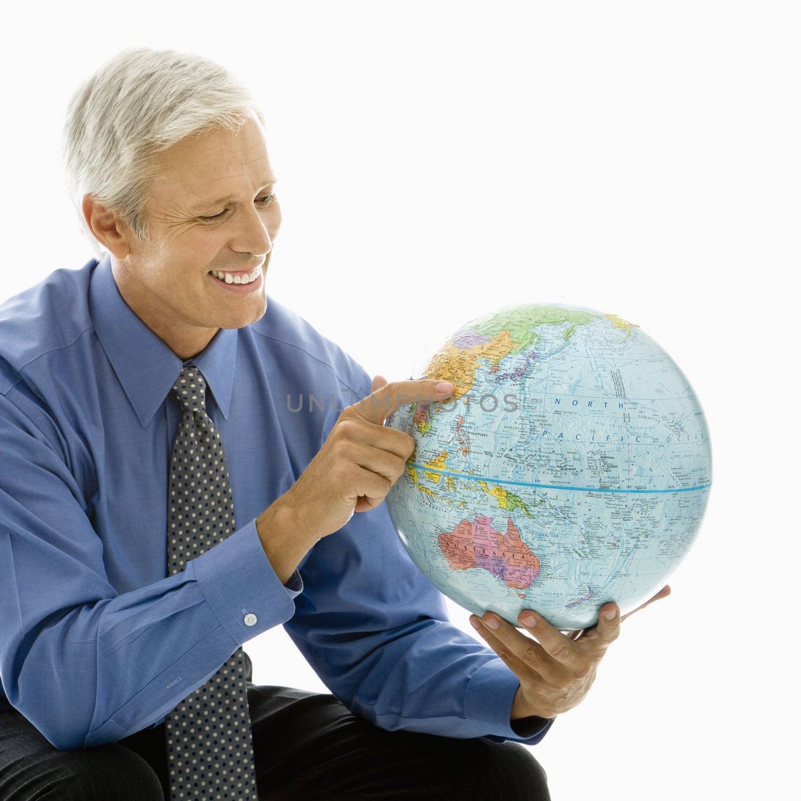 Middle aged Caucasian man pointing on globe.