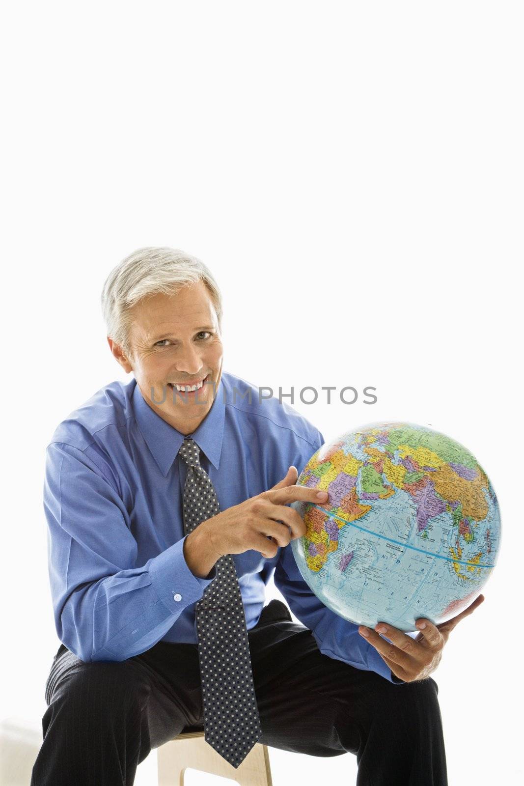 Middle aged Caucasian man pointing on globe.