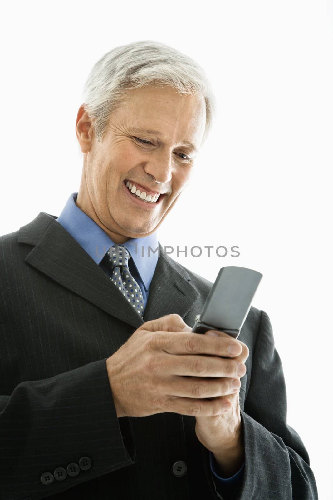 Caucasian middle aged man smiling and text messaging on cell phone.