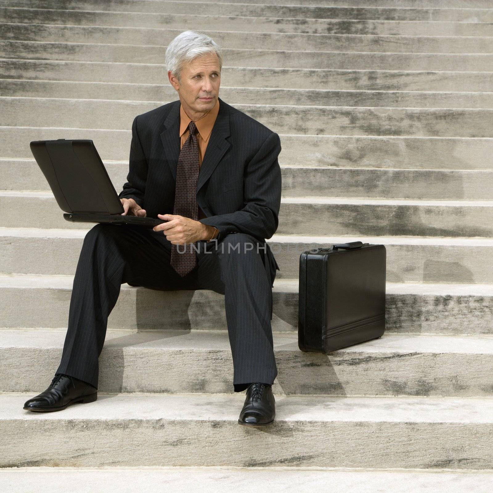 Businessman on steps. by iofoto