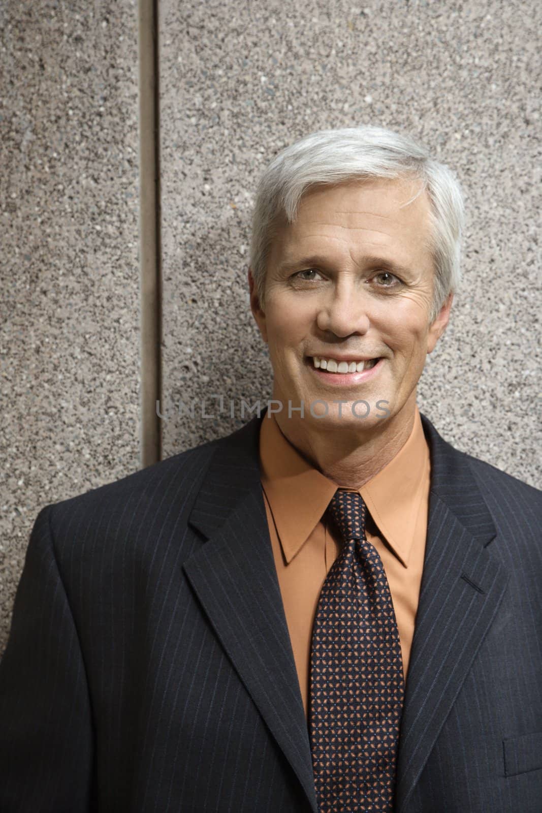Caucasian middle aged businessman smiling at viewer.