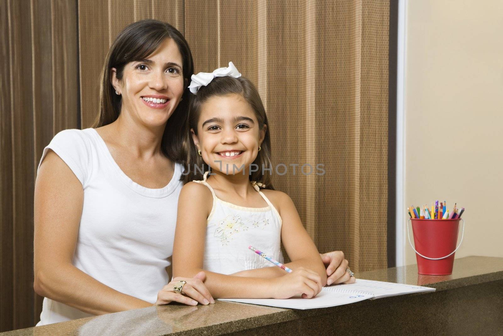 Hispanic mother and daughter portrait with homework.