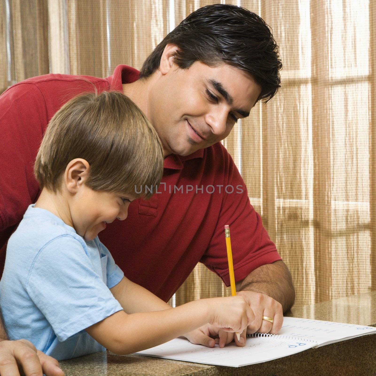 Hispanic father helping son with homework.