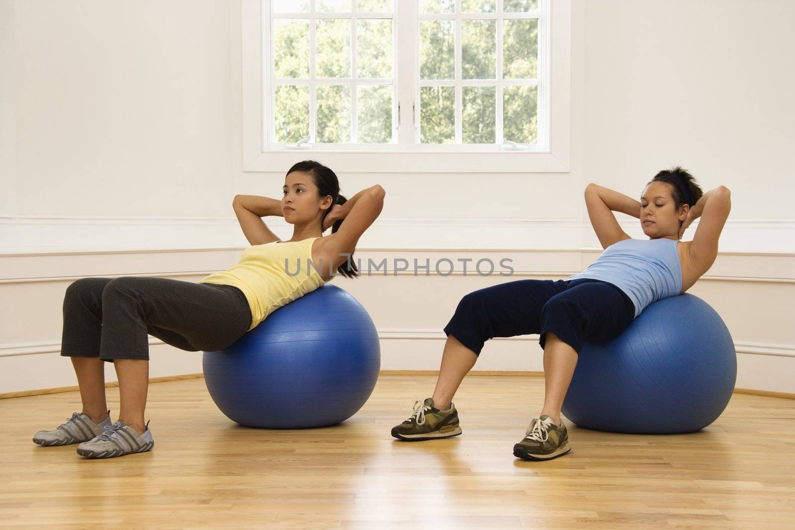 Women doing ab workout by iofoto