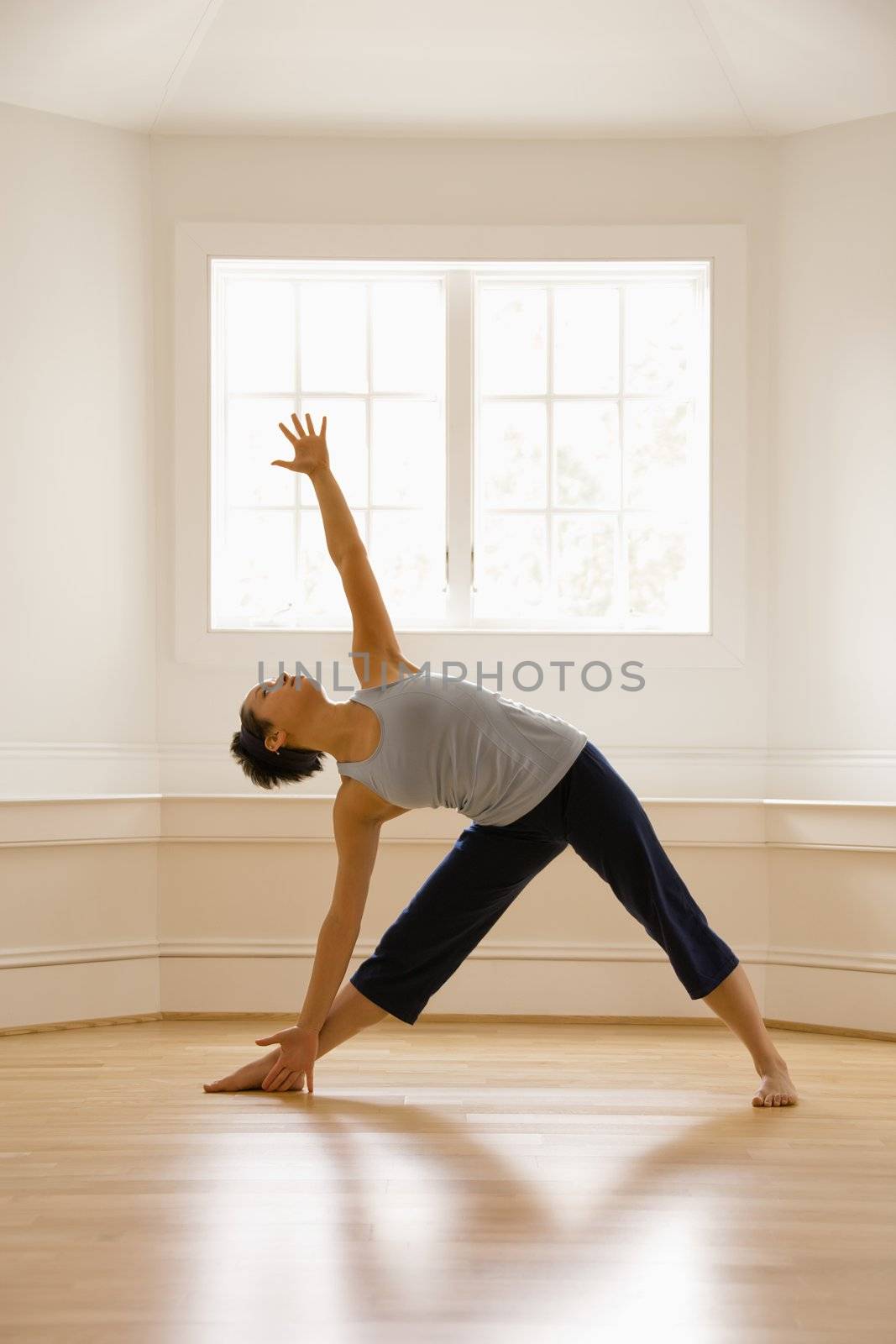 Yoga triangle pose by iofoto