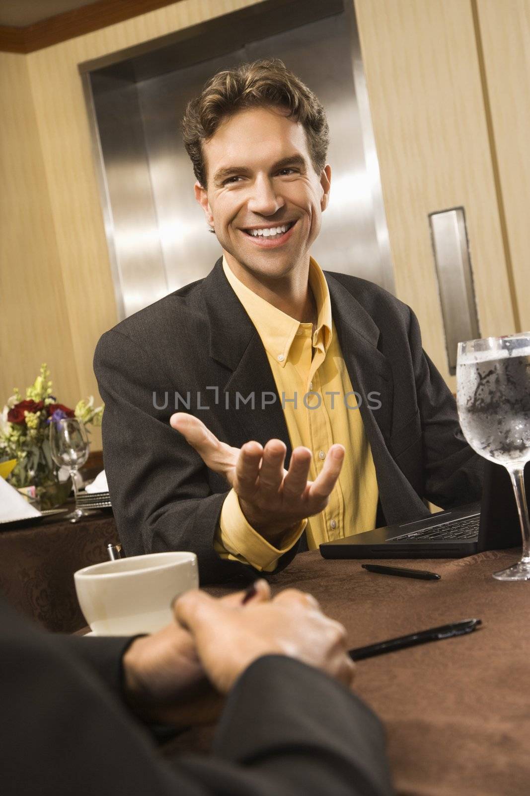 Caucasian businessman gesturing during meeting.