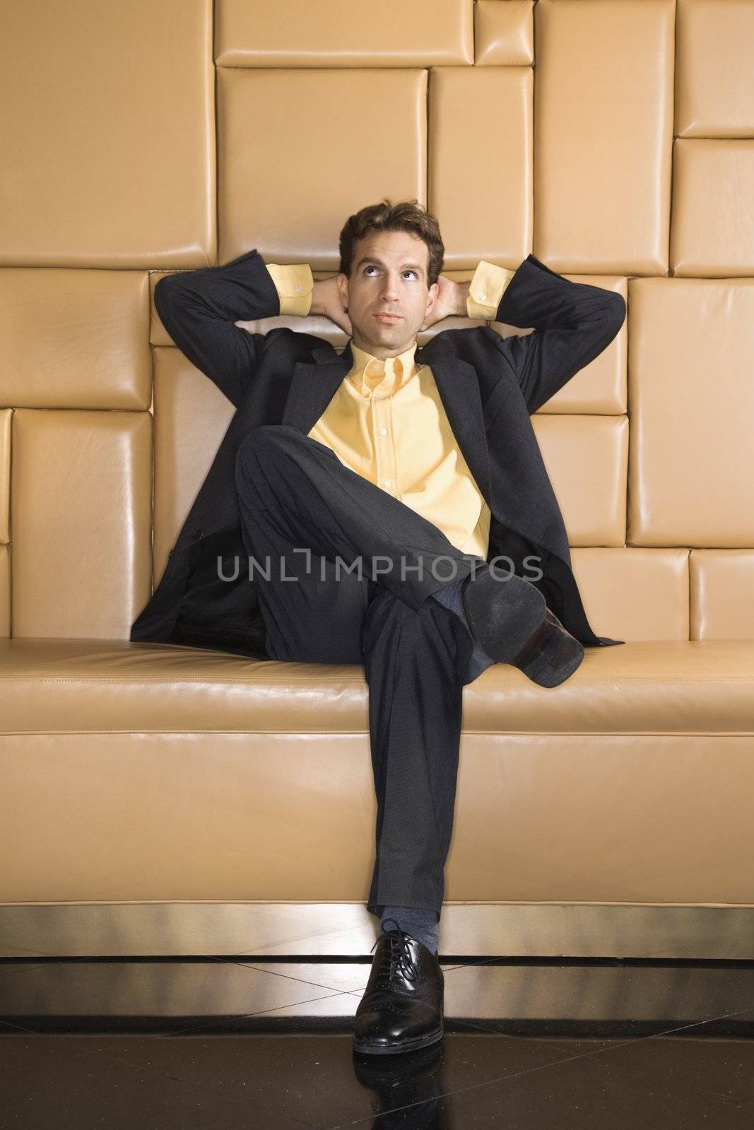 Caucasian businessman with hands behind head rolling eyes.