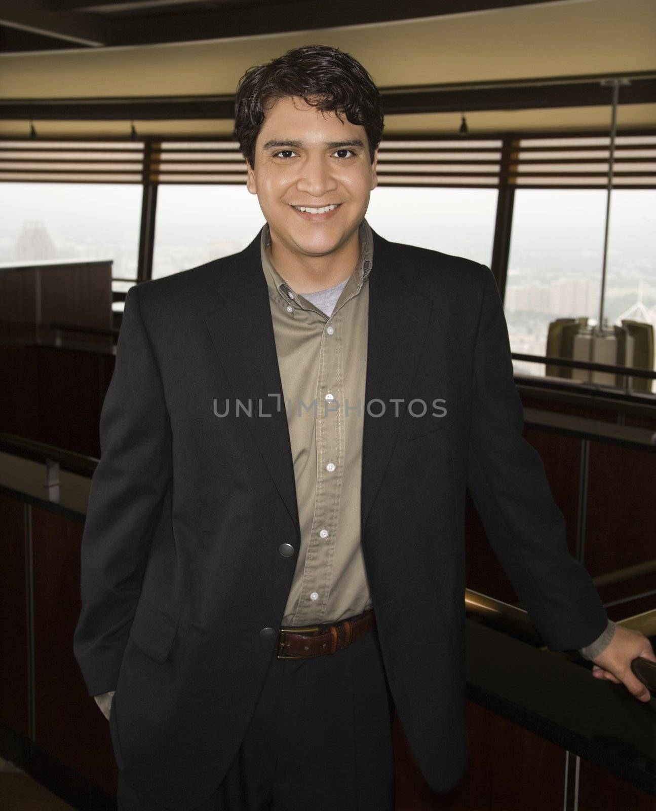 Businessman standing and smiling at viewer.