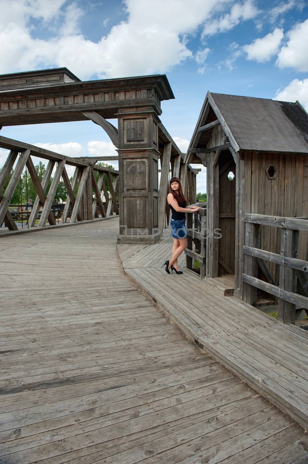 View of young, sexy woman, old-time bridge and watch box.
