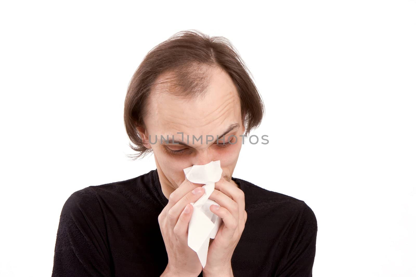 The man sneezes in a white paper handkerchief