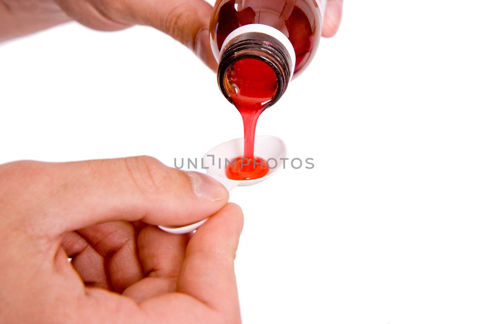 On a white background the hand pours children's mixture in a spoon