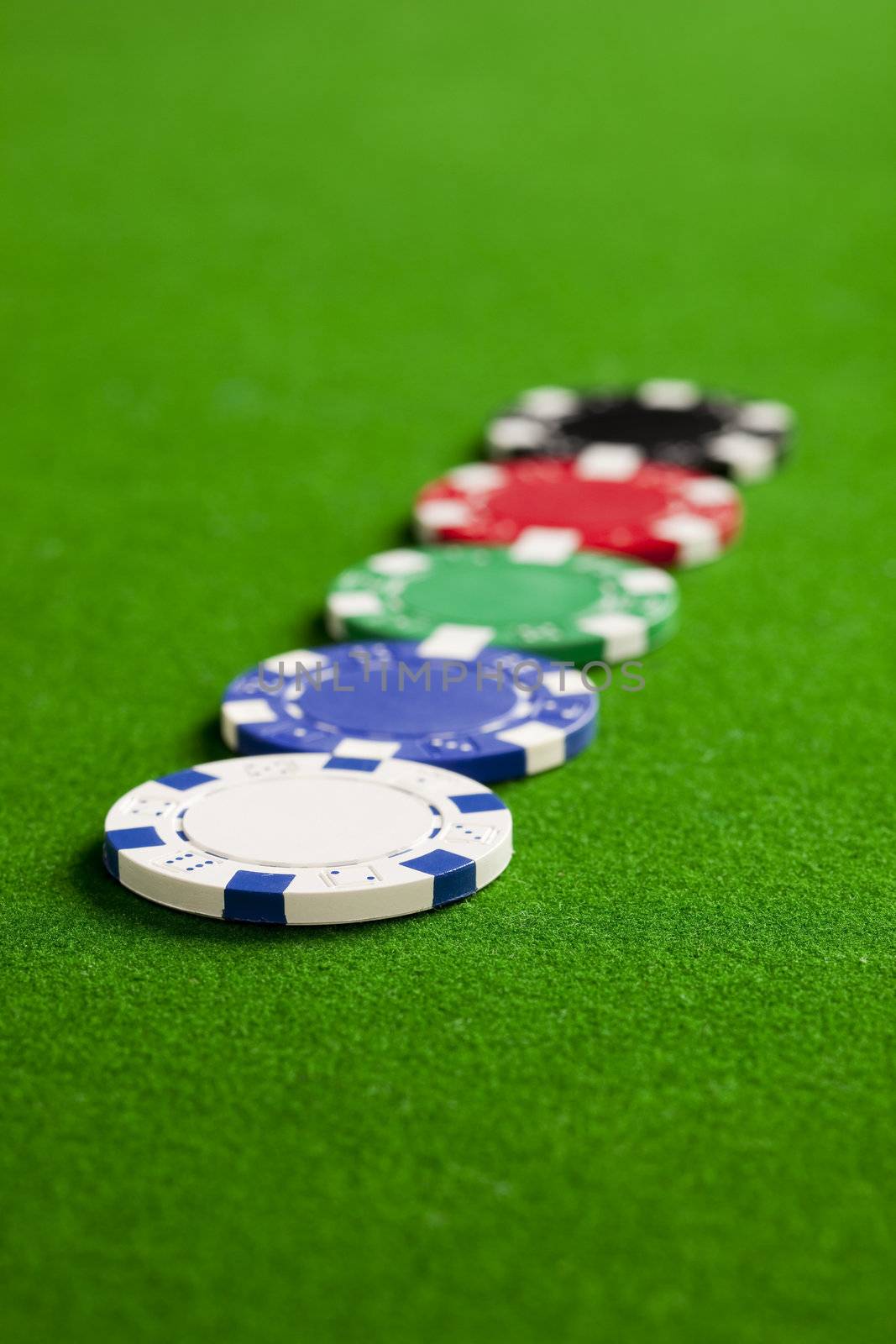 Blank casino chips on the green gaming table