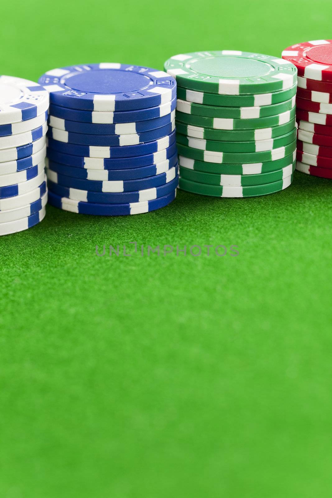 Blank casino chips on the green gaming table
