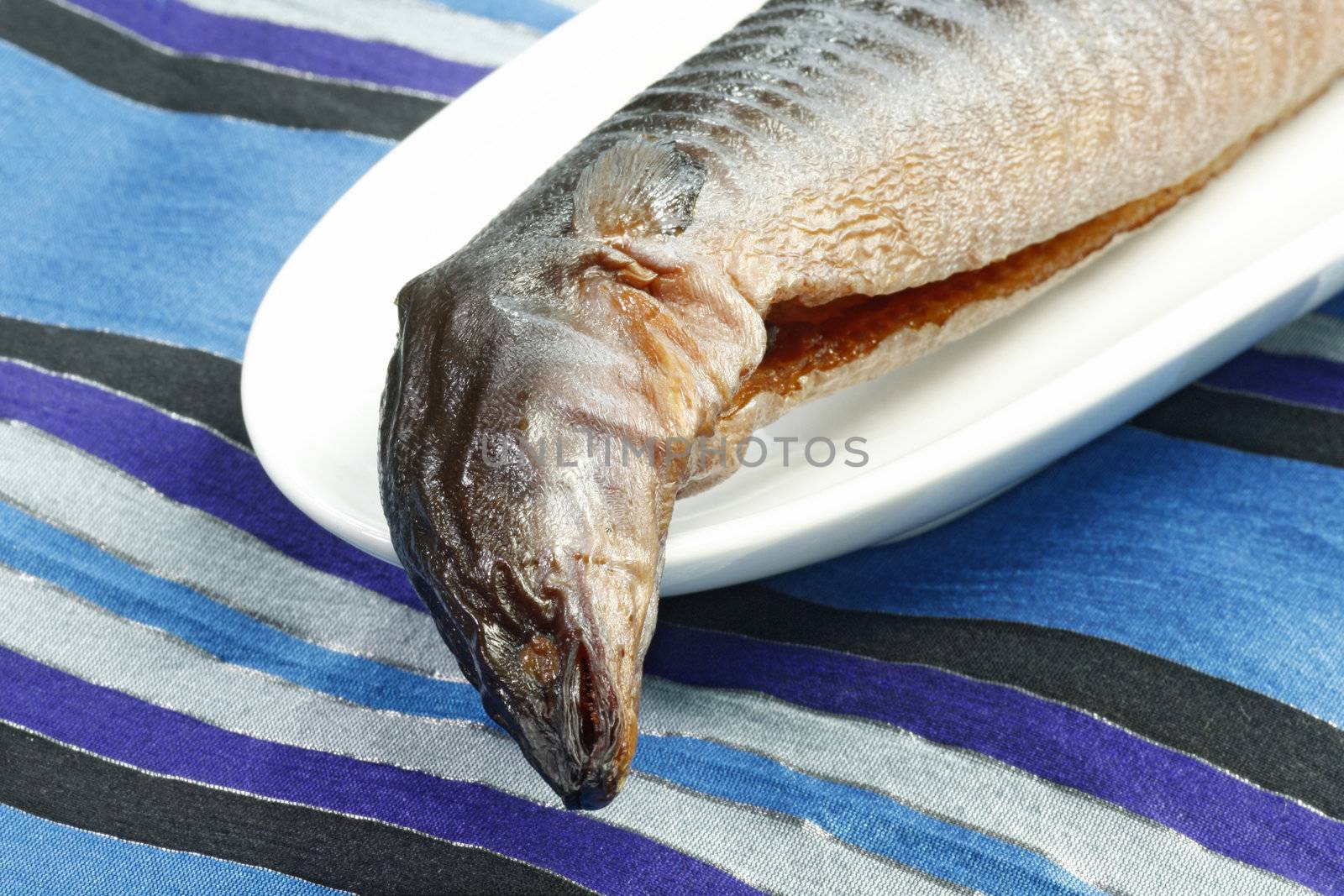 Whole smoked eel with garnish on a plate