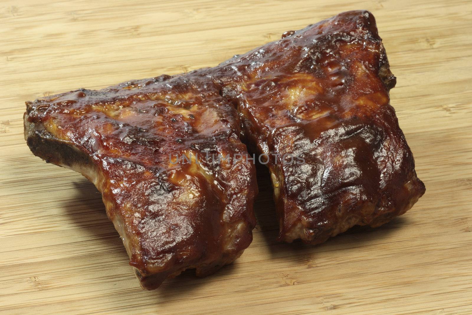 Grilled spare ribs on a wooden plate